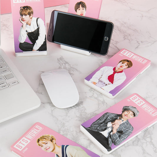 (One) BTS - BTS World Official :  BTS WORLD High Speed ​​Wireless Charging Base دع  حامل وشاحن جيمي او  كوكي او احد شخصيات بي تي اس يحملون و يشحنون موبايلك  او جوالك  وانت تقراء او تتصفح مجله 